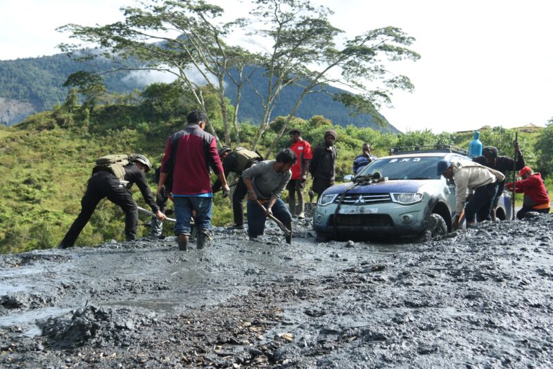 Satgas Yonif 112/DJ Kodam IM bersama masyarakat Bersihkan material Longsor di jalan Trans Papua Puncak Jaya. Foto: Dok. Pendam IM