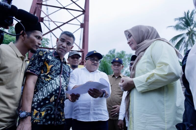 Ketua Tim Penggerak PKK Aceh, Marlina Muzakir, didampingi Kepala Dinas PUPR Aceh, Mawardi, dan Wakil Bupati Aceh Utara, Tarmizi meninjau lokasi Jembatan Krueng Sawang di Kecamatan Sawang, Aceh Utara, Selasa, 22/4. Jembatan tersebut ambruk ke sungai pada awal tahun 2025 akibat tergerus derasnya arus sungai saat pembongkaran. Foto: Dok. Ist