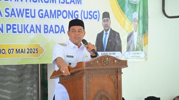 Bupati Aceh Besar H Muharram Idris (Syech Muharram) menyampaikan sambutannya pada sosialisasi fatwa dan hukum Islam dalam rangka pelaksanaan program Ulama Saweu Gampong (USG) di Kecamatan Peukan Bada, di Meunasah Gampong Lam Geu Eu, Kecamatan Peukan Bada, Kabupaten Aceh Besar, Rabu (7/5/2025). 