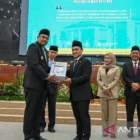 Gubernur Sumatera Utara Bobby Nasution (kiri) menerima laporan hasil pemeriksaan LKPD Pemprov Sumut tahun anggaran 2024 diserahkan anggota IV BPK RI Haerul Saleh dalam rapat paripurna di Gedung DPRD Sumut, Kamis (12/6/2026). FOTO: dok. ANTARA/HO-Diskominfo Sumut