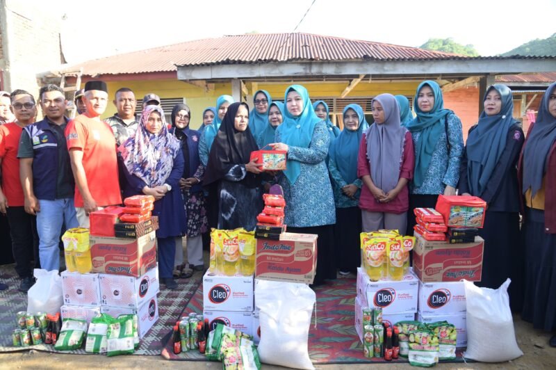 Ketua TP PKK Aceh Besar Hj Rita Mayasari menyerahkan bantuan masa panik kepada korban bencana angin kencang, di Lampasi Engking, Kecamatan Darul Imarah, Kabupaten Aceh Besar, Jumat (13/6/2025). Foto: Dok. MC Aceh Besar