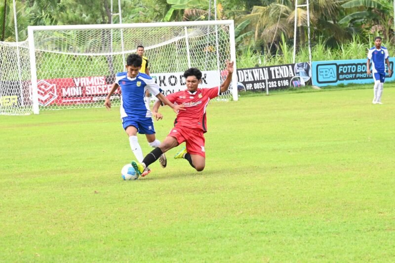 Pemain Pra PORA Aceh Besar (kaos biru) mencoba merebut bola dari pemain Pemain Pra PORA dalam laga uji coba di Lapangan Bola Amla, Kecamatan Ingin Jaya, Aceh Besar, Sabtu (21/06/2025). Foto: Ist