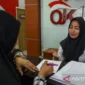 Ilustrasi - Karyawati melayani warga yang membuat pengaduan masalah keuangan di Kantor Otoritas Jasa Keuangan (OJK) Perwakilan Sulawesi Tengah. dok. ANTARA FOTO/Basri Marzuki/ama/aa.