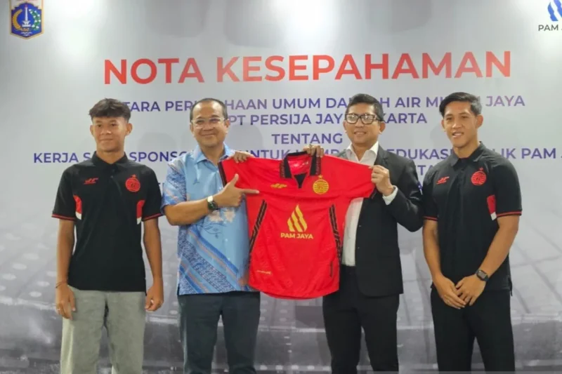 Pemain Persija Muhammad Zahabi Gholy, Direktur Utama PAM Jaya Arief Nasrudin, Presiden Persija Jakarta Mohammad Prapanca, dan pemain Persija Eksel Runtukahu (ki-ka) berfoto setelah acara penandatanganan nota kesepahaman antara PAM Jaya dan Persija di Jakarta, Kamis (3/7/2025). (ANTARA/RAUF ADIPATI)