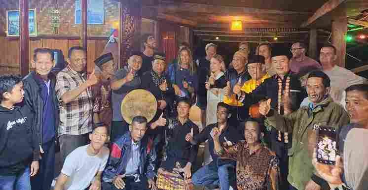 Camat Ikhwan Jamil bersama seniman simeulue berswafoto dengan turis manca negara.(Foto: AgusMuliadi/Acehnow).