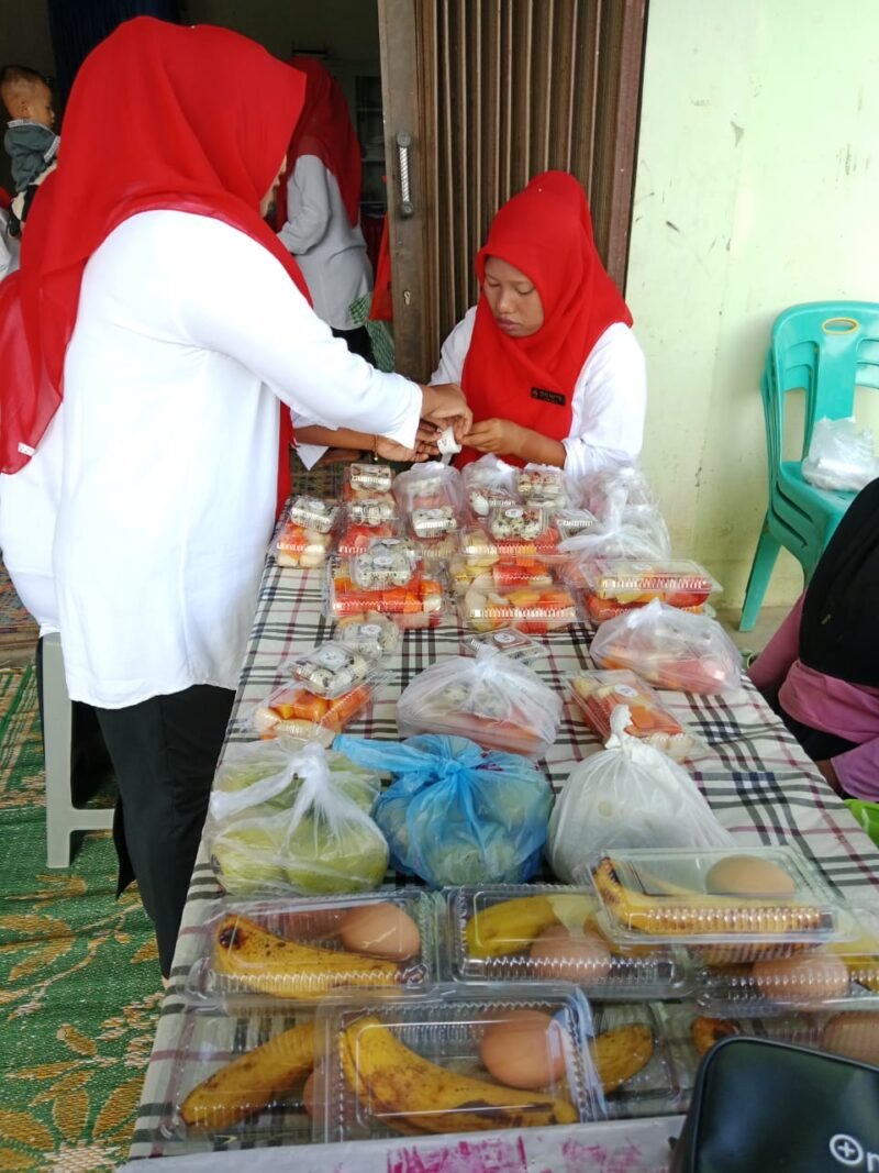 ibu kader Posyandu melayani pembagian makanan tambahan (PMT) berupa buah, telur, dan aneka kue untuk balita, ibu hamil, dan lansia pada kegiatan Posyandu.Foto.Dok: Rahmat Ramadhan/Acehnow 