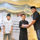 Bupati Aceh Besar Muharram Idris bagikan hadiah lomba Bakti Sosial PP HIMAB di Halaman Masjid Darul Muttaqin, Gampong Lamtamot, Sabtu (23/8/2025) malam. dok. MC ACEH BESAR