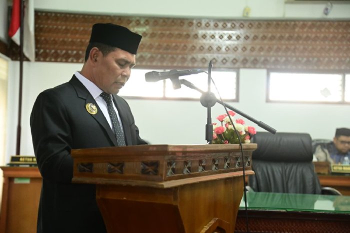 H Muharram Idris menyampaikan penjelasan Bupati Aceh Besar terhadap rancangan Qanun tentang pengelolaan keuangan daerah dan rancangan Qanun tentang penyelenggaran cadangan pangan, bertempat di Ruang Rapat Paripurna DPRK,Kamis (18/09/2025). dok. MC Aceh Besar