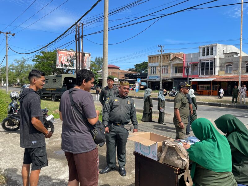 Petugas Satpol PP dan WH Aceh Besar melakukan pendataan terhadap pengendara yang terjaring razia busana islami, di depan Gedung Wali Nanggroe Aceh, Gampong Lamblang Manyang, Kecamatan Darul Imarah, Aceh Besar, Kamis (25/9/2025). FOTO: MC ACEH BESAR