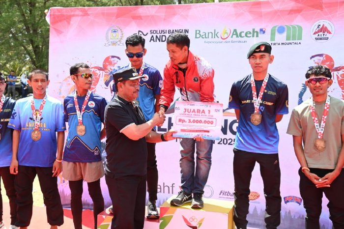Wakil Bupati Aceh Besar Drs H Syukri A Jalil menyerahkan hadiah kepada pemenang lomba Trail Running 2025 di Pantai Teubing Lampuuk, Kecamatan Lhoknga, Aceh Besar, Minggu (31/08/2025). DOK. MC ACEH BESAR