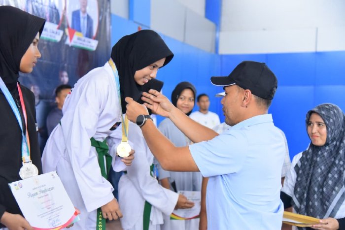 Ketua DPRK Aceh Besar Abdul Muchti mengalungi Medali kepada Juara Taekwondo PORKAB 2025 di JSC, Kota Jantho, Selasa (9/9/2025) DOK. MC ACEH BESAR