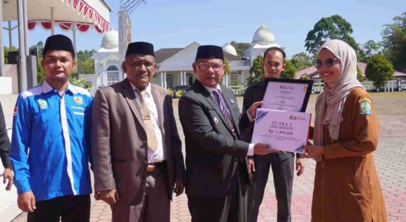 Wakil Bupati Simeulue, Nusar Amin S.Pd didampingi Kadispora Suhelmi,. Dan ketua KNPI Eriton saat menyerahkan uang pembinaan. (Foto: AgusMuliadi/Acehnow).