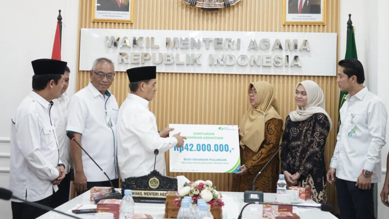 Wamenag Romo Syafi’i menyerahkan santunan kepada keluarga almarhum petugas haji Budi Iskandar Pulungan. dok. Kemenag RI