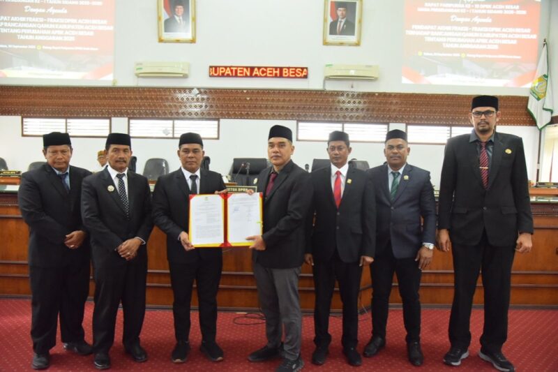 Bupati Aceh Besar H Muharram Idris didampingi Wabup Drs H Syukri, Sekda Bahrul Jamil SSos MSi bersama Pimpinan DPRK Aceh Besar memperlihatkan dokumen persetujuan Raqan Kabupaten Aceh Besar Tentang Perubahan APBK menjadi Qanun APBK-P Aceh Besar TA 2025, dalam sidang paripurna, di Gedung DPRK Aceh Besar, Kota Jantho, Selasa (30/9/2025) siang. dok. MC ACEH BESAR
