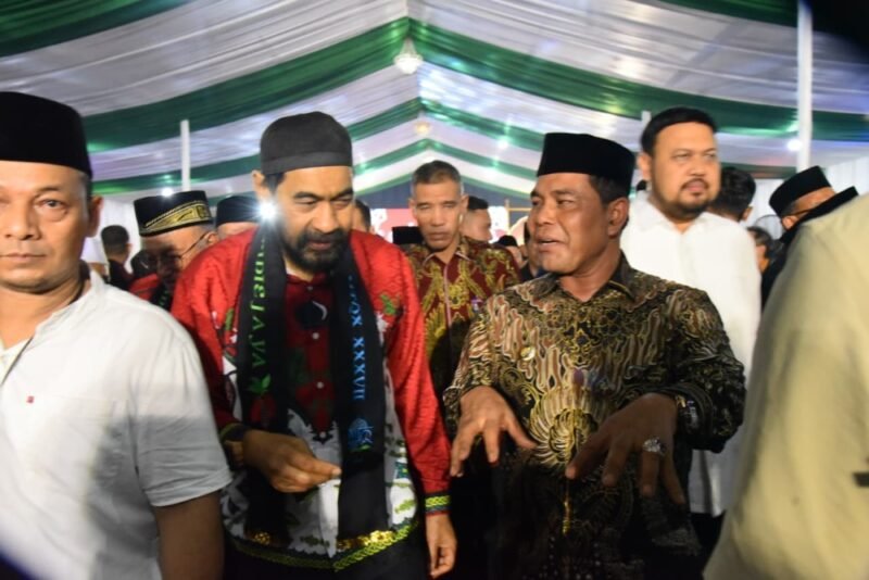 Bupati Aceh Besar H Muharram Idris (Syech Muharram) berdialog dengan Gubernur Aceh Muzakir Manaf (Mualem), pada gala dinner pembukaan MTQ XXXVII tingkat Provinsi Aceh tahun 2025, di halaman Kantor Bupati Pidie Jaya, Sabtu (1/11/2025) malam. FOTO: MC ACEH BESAR