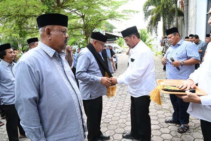 Wakil Bupati Aceh Besar Drs H Syukri A Jalil, mengalungkan sal kepada Ketua Kafilah, Farhan AP, Sekretaris kafilah Rusdi SSos MSi pada acara penyambutan Kafilah Aceh Besar saat tiba di Gedung Dekranasda, Gampong Gani, Kecamatan Ingin Jaya, Aceh Besar. dok. MC Aceh Besar