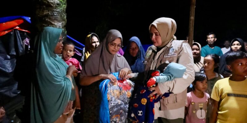 Ketua TP PKK Aceh, Marlina Muzakir, menyerahkan bantuan tanggap darurat kepada warga terdampak banjir bandang di Kecamatan Langkahan, Aceh Utara, Selasa (16/12/2025) malam. Foto: Dok. Biro Adpim Setda Aceh 