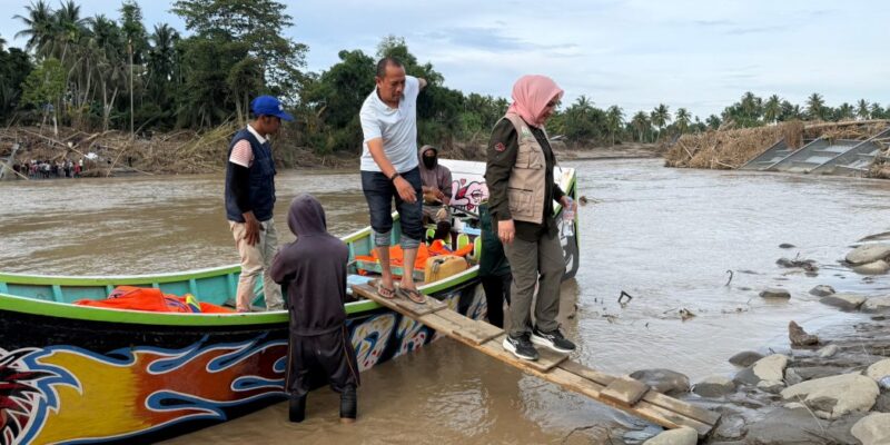Ketua TP-PKK Aceh Marlina Muzakir menyeberangi Krueng Peusangan menggunakan boat nelayan saat mengantarkan bantuan ke Gampong Kubu, Kecamatan Peusangan Siblah Krueng, Bireuen, Minggu (14/12/2025). Foto: Dok. Biro Adpim Setda Aceh