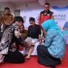 Plt. Kepala Dinas Sosial Aceh Chaidir bersama Ketua TP PKK Aceh Marlina Muzakir saat menyerahkan bantuan kaki palsu kepada penyandang disabilitas pada peringatan Hari Disabilitas Internasional 2025 di Banda Aceh, Selasa (30/12/2025). Foto: Dok. Istimewa