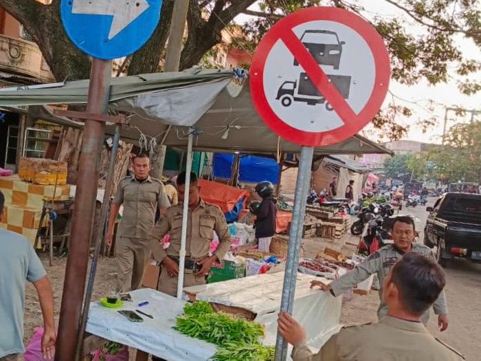 Petugas Satpol PP dan WH Aceh Besar menertibkan lapak Pedagang Kaki Lima yang berjualan di bahu jalan Pasar Induk Lambaro, Kecamatan Ingin Jaya, Aceh Besar, Senin (19/1/2026). Foto: Dok. MC Aceh Besar