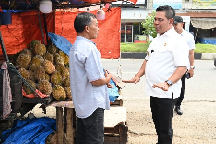 Bupati Aceh Besar, H Muharram Idris berdialog dengan pedagang buah durian saat tinjau para pedagang di pinggir jalan nasional depan MPP Lambaro, Kecamatan Ingin Jaya, Aceh Besar, Rabu (21/01/2026). Foto: Dok. MC Aceh Besar