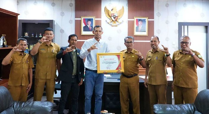 Foto bersama Sekretaris DPRA Khudri dan jajaran PPID Sekretariat DPRA saat menerima penghargaan “Informatif” dari Ketua Komisi Informasi Aceh, Selasa (20/1/2026). Foto: Dok. DPRA