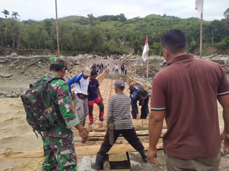 Ket foto: Satgas Rekonbencal Koramil 09/Ketol bersama warga memperbaiki jembatan darurat di Desa Bergang.(Dok: Ist)