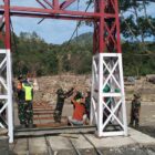 Ket Foto: Personel TNI bersama warga melaksanakan pemasangan dan pengelasan hanger pada pembangunan Jembatan Gantung Desa Burlah.(Dok: Ist)