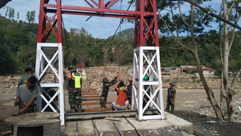 Ket Foto: Personel TNI bersama warga melaksanakan pemasangan dan pengelasan hanger pada pembangunan Jembatan Gantung Desa Burlah.(Dok: Ist)