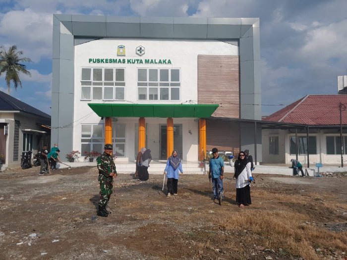 Kepala Puskesmas Kuta Malaka dr. Eli Diana bersama Camat Kuta Malaka Muzakkir, SE, unsur Muspika, dan lintas sektor saat gotong royong meuseraya dalam rangka menyambut bulan suci Ramadhan dan mendukung inovasi Puskesmas Geberling Malaka, Rabu (11/2/2026). Foto: Dok. MC Aceh Besar