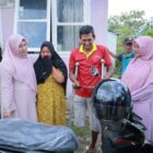 Ketua TP-PKK Aceh Besar Hj. Rita Mayasari menyerahkan sepeda motor roda tiga modifikasi kepada Musliadi M. Yusuf, penyandang disabilitas di Gampong Lam Manyang, Sabtu (14/02/2026). Foto: Dok. Mc Aceh Besar