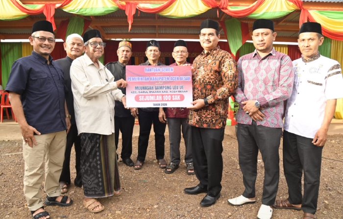 Kadis PMG Aceh Besar, Jakfar SP, M.Si, menyerahkan 100 sak semen secara simbolis kepada Imuem Meunasah Gampong Leu Ue di Pasar Mini BUMG Gampong Leu Ue, Kecamatan Darul Imarah, Aceh Besar, Kamis (19/2/2026). Foto: Dok. Mc Aceh Besar