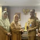 Kepala Dinas Perpustakaan dan Kearsipan Aceh (DPKA), Syaridin (kedua kanan), bersama jajaran staf menunjukkan piala penghargaan dari Arsip Nasional Republik Indonesia (ANRI) atas capaian digitalisasi arsip dengan predikat AA, di Banda Aceh, Selasa (24/2/2026). Foto: Dok. Istimewa