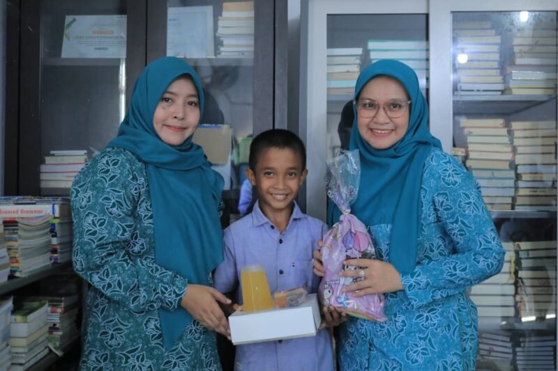 Ketua TP PKK Banda Aceh Dessy Maulidha menyerahkan bantuan kepada anak panti asuhan dalam kegiatan berbagi Ramadan di kawasan Seutui, Jumat (27/2/2026). Foto: Dok. Prokopim Kota Banda Aceh