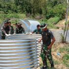 Personel TNI Kodam Iskandar Muda bersama warga melakukan pemasangan rangka jembatan Armco di wilayah pedalaman Aceh untuk membuka akses transportasi, Minggu (22/3/2026). Foto: Dok. Istimewa
