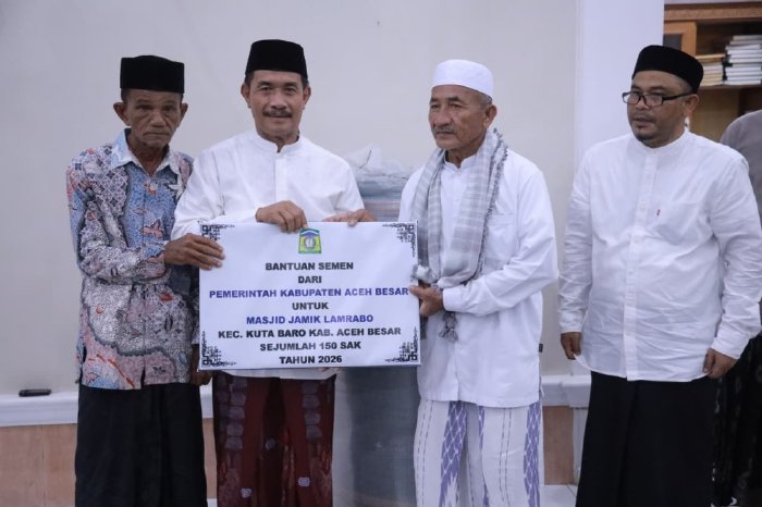 Wakil Bupati Aceh Besar Drs Syukri A Jalil menyerahkan bantuan 150 sak semen dan ambal sajadah kepada pengurus Masjid Jamik Lamrabo saat Safari Ramadhan di Gampong Deyah, Kecamatan Kuta Baro, Minggu (1/3/2026). Foto: Dok. MC Aceh Besar