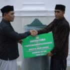 Bupati Aceh Besar Muharram Idris menyerahkan bantuan 150 sak semen dan ambal sajadah kepada pengurus Masjid Leupung dalam rangka Safari Ramadhan, Senin (2/3/2026). Foto: Dok. MC Aceh Besar