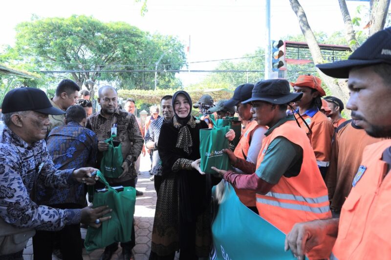 Wali Kota Banda Aceh Illiza Sa’aduddin Djamal bersama Dirut Bank Aceh Syariah Fadhil Ilyas menyerahkan bingkisan Lebaran kepada petugas kebersihan DLHK3 Banda Aceh, Jumat (13/3/2026). Foto: Dok. Prokopim Kota Banda Aceh
