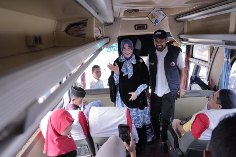 Wali Kota Banda Aceh Illiza Sa’aduddin Djamal bersama Gubernur Aceh Muzakir Manaf menyapa para pemudik di dalam bus sebelum keberangkatan program Mudik Gratis Pemerintah Aceh tahun 2026 di Terminal Batoh, Minggu (15/3/2026). Foto: Dok. Prokopim Kota Banda Aceh