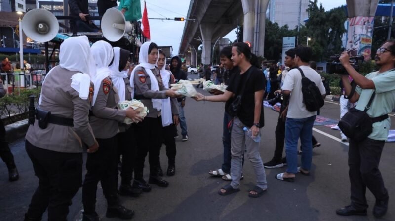 Polwan membagikan paket makanan kepada warga saat kegiatan sosial di bawah jalur layang kawasan Jakarta, Rabu (4/3/2026). Foto: Dok. Istimewa