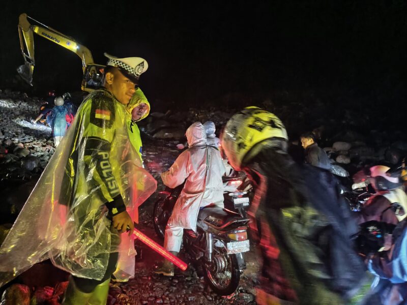 Ket foto : Personel Satlantas Polres Bener Meriah bersama anggota Polsek Pintu Rime Gayo dan warga membantu pengendara sepeda motor melintasi jalan berbatu dan licin di tengah hujan malam.(Dok: Ist/Rahmat Ramadhan.Acehnow)