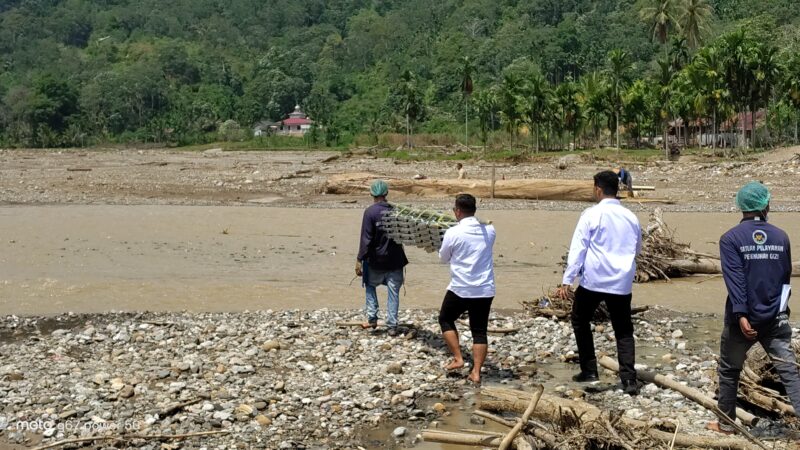 Relawan MBG harus berjalan melintasi aliran sungai demi mengantarkan hak gizi anak-anak tepat waktu, pada Rabu (8/4/2026). Foto: BGN