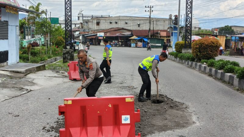 Ket Foto : Kasat Lantas Polres Bener Meriah, AKP Syafaruddin, turun langsung bersama personel menambal jalan berlubang.(Dok: Ist)