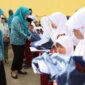 Bunda Guru Aceh, Ny. Marlina Muzakir, didampingi Ketua Dharma Wanita Persatuan Aceh Ny. Malahayati M. Nasir, membagikan paket seragam sekolah dan paket olahan serba ikan kepada Sisea-Siswi di SD Negeri Tanah Rata, Aceh Timur, Rabu (15/4/2026). Foto: Dok. Biro Adpim Setda Aceh 