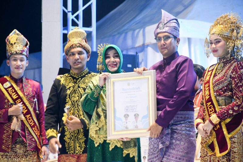 Wali Kota Banda Aceh Illiza Sa’aduddin Djamal menyerahkan Banda Aceh Collaboration Award 2026 kepada salah satu penerima di Blang Padang, Rabu (22/4/2026). Foto: Dok. Prokopim Kota Aceh