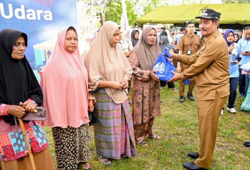 Wakil Bupati Aceh Besar Drs H Syukri A Jalil menyerahkan sembako Bazar Murah kepada masyarakat dalam rangka HUT Ke-80 TNI Angkatan Udara di halam Kantor Camat Blang Bintang, Aceh Besar, Selasa (14/04/2026). Foto: Dok. MC Aceh Besar