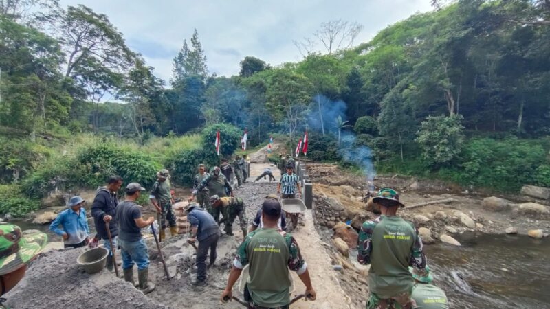 Ket foto : Personel Koramil 01/Bandar bersama masyarakat bergotong royong mengerjakan pembangunan jembatan Aramco di aliran sungai yang menghubungkan Desa Pakat Jeroh dengan Desa Bintang Baru.(Dok: Ist)