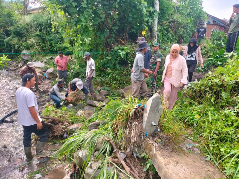 Ket foto : Babinsa Koramil 03/TG bersama warga mengumpulkan material untuk pembangunan jembatan darurat di Desa Lampahan Barat, Sabtu (9/5/2026).(Dok: Ist)