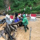 Ket foto : Babinsa bersama warga memantau luapan Sungai Wih Gegaring yang menggenangi Jembatan Aramco di Desa Pantan Sinaku.(Dok/Ist)