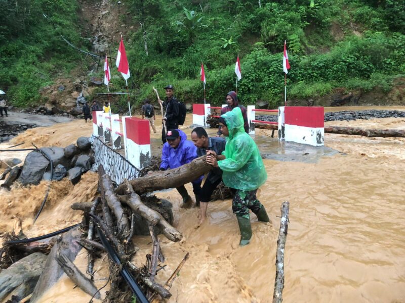 Ket foto : Babinsa bersama warga memantau luapan Sungai Wih Gegaring yang menggenangi Jembatan Aramco di Desa Pantan Sinaku.(Dok/Ist)